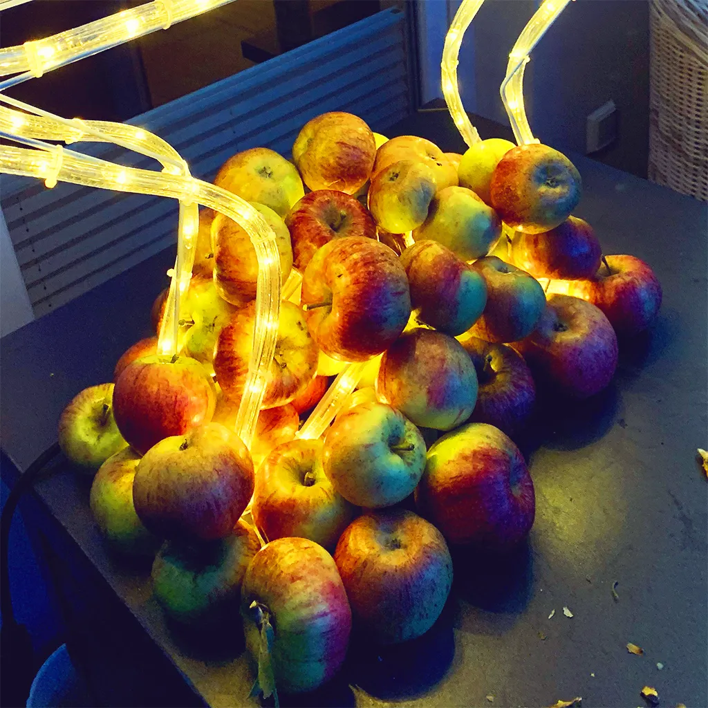 Äpfel mit warmer Lichterkette zum Tag des Apfels