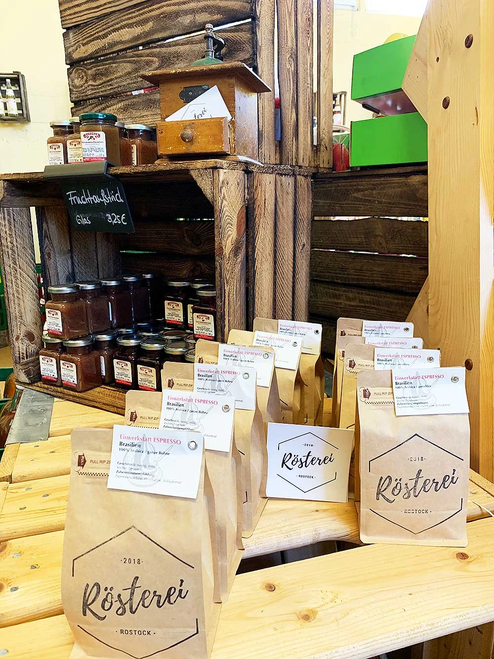 Kaffeebohnen-Tüten und Marmeladengläser im Hofladen-Regal